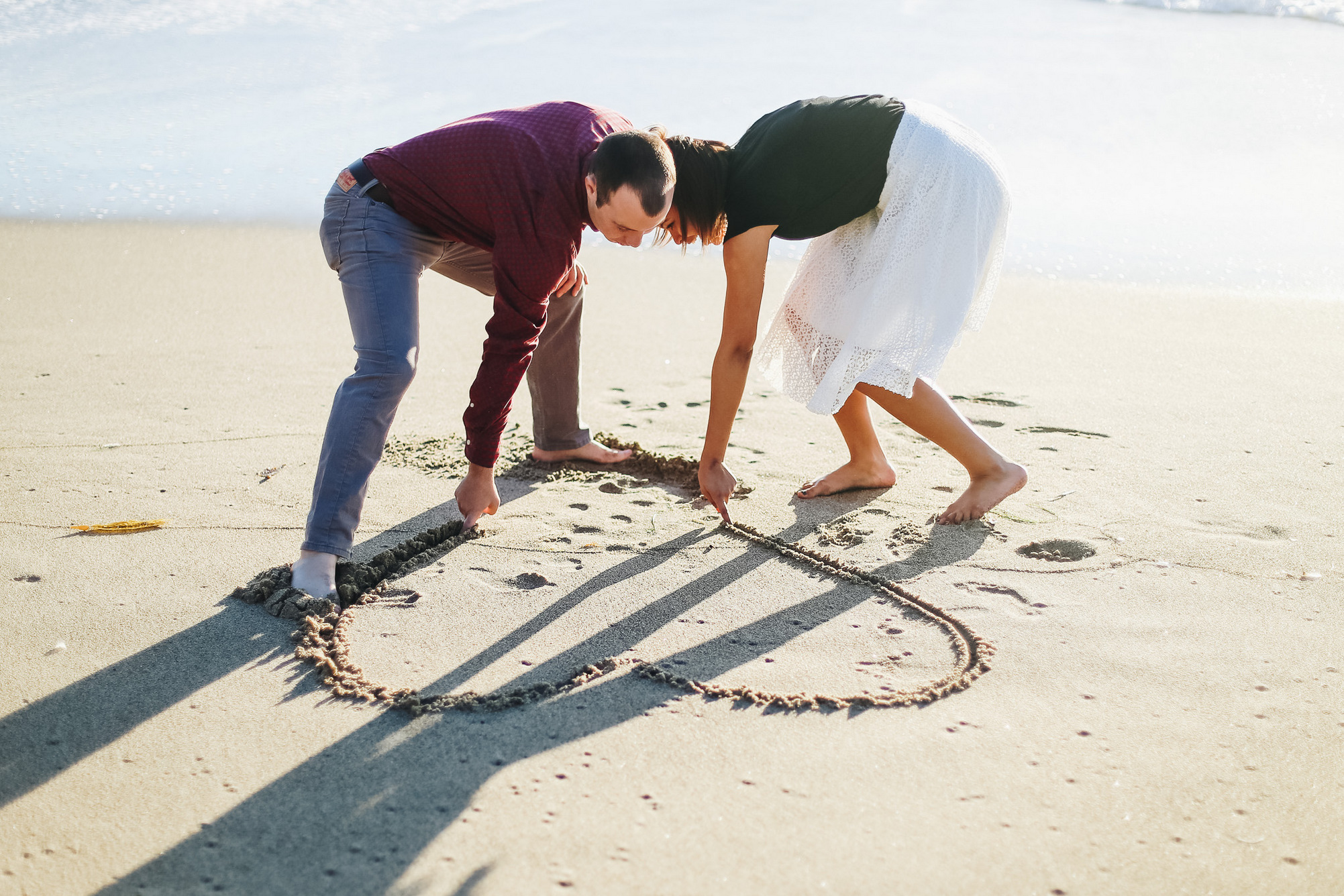 drawing hearts in the sand -- engagement photos on point dume state beach in california